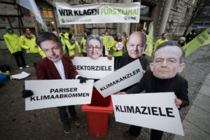 Aktivisten mit Masken stehen vor dem Oberverwaltungsgericht Berlin.