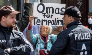 Ein Mitglied der Gruppe Letzte Generation zeigt ein Schild mit der Aufschrift «Omas für Tempolimit».