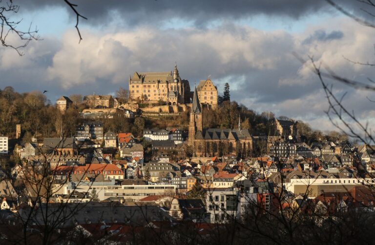 Wolken ziehen über Marburgs Schloss und der Altstadt vorbei. Foto: Nadine Weigel/dpa