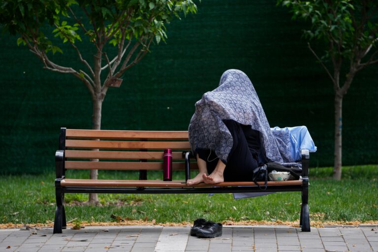 Eine Frau in China schützt sich mit einem Tuch vor der Sonne. Foto: Andy Wong/AP