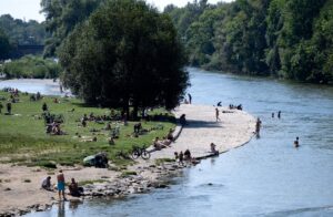 Zahlreiche Menschen genießen das sonnige Wetter in der Münchner Innenstadt am Ufer der Isar. (Archivbild)