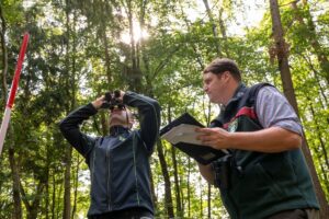 Die Landesinventurleiter für die Waldzustandserhebung, Michael Heym (l) und Wolfgang Stöger (r), schauen Bäume an.