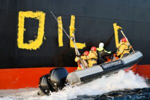 Aktivisten der Umweltorganisation Greenpeace malen den Schriftzug «Oil fuels war» auf den Rumpf eines Schiffes, das russisches Öl auf der Ostsee transportiert. (Archivbild)