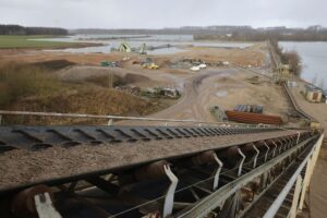 Ein Förderband transportiert Sand am Baggersee der Weeze Kies GmbH & Co.KG der Hülskens Holding. Bei den Klagen gegen den Regionalplan Ruhr geht es neben weiteren Streitpunkten auch um den Kiesabbau. (Archivbild)