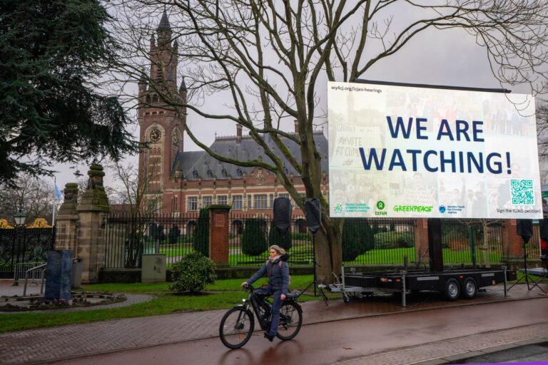 «We are Watching!» ist auf einem Plakat vor dem Internationalen Gerichtshof zu lesen: Das höchste UN-Gericht hat sich mit Klimaschutz befasst. (Archivbild) Foto: Peter Dejong/AP/dpa