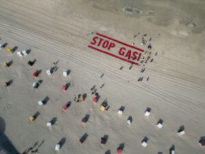 Klimaschutzaktivisten von Fridays for Future schreiben ihre Forderung nach einem Ende der Gasförderung auf den Strand der Insel Borkum.