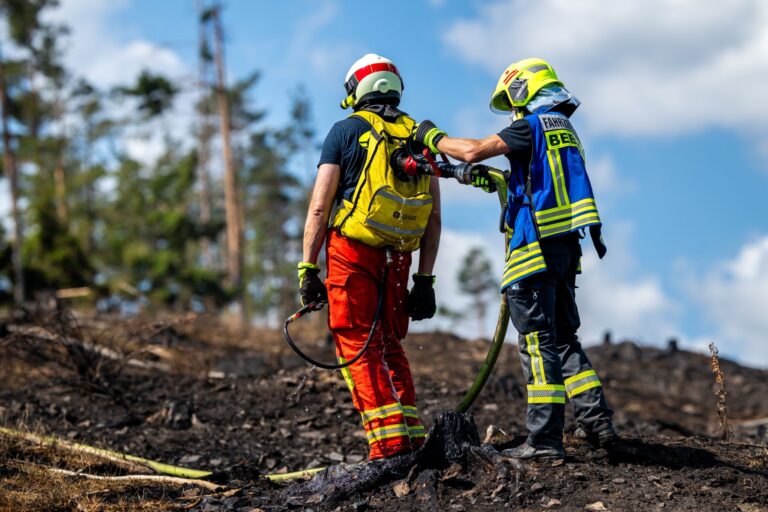 Mit Löschrucksäcken gehen die Feuerwehrleute etwa gegen Glutnester vor.  Foto: Jacob Schröter/dpa