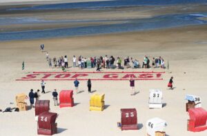 Klimaschutzaktivisten von Fridays for Future schreiben ihre Forderung nach einem Ende der Gasförderung auf den Strand der Insel Borkum.