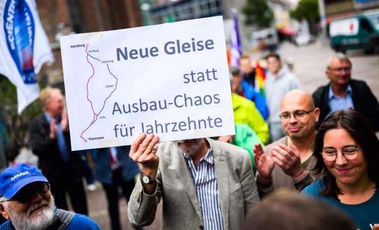 Menschen demonstrieren für den Neubau der Bahnstrecke Hamburg-Hannover.  Foto: Julian Stratenschulte/dpa
