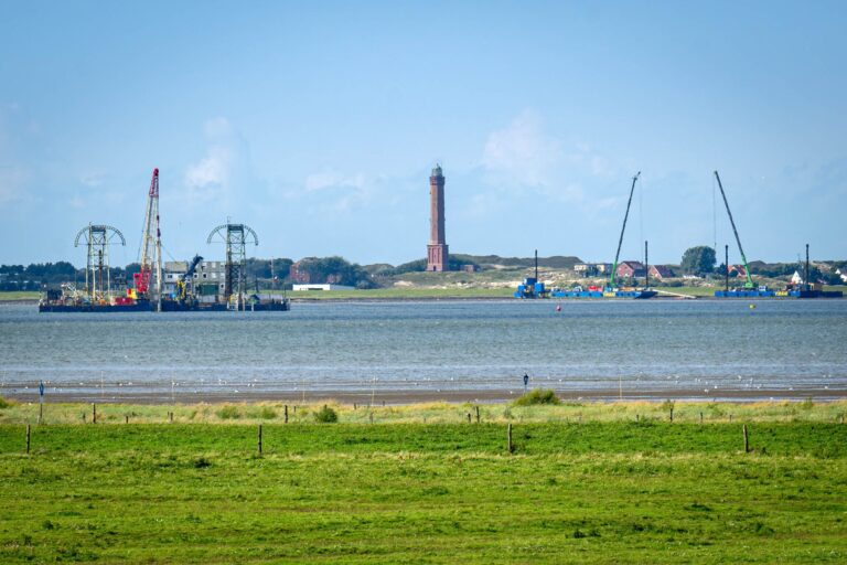 Vom Festland aus ist das Kabelverlegeschiff «Barbarossa» im Watt vor Norderney zu sehen.  Foto: Sina Schuldt/dpa