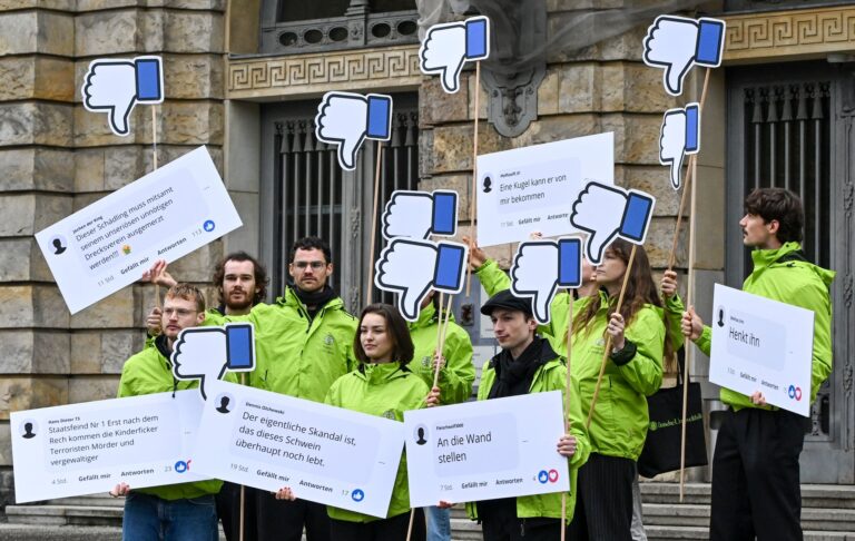 Demonstranten der Deutschen Umwelthilfe (DUH) stehen mit Plakaten vor dem Kammergericht Berlin. Foto: Jens Kalaene/dpa