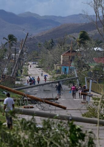 Bewohner gehen durch Lacovia Tombstone nach dem Durchzug des Hurrikans «Melissa». Foto: Matias Delacroix/AP/dpa