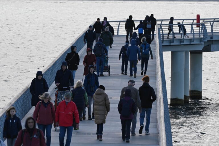 Auch bei herbstlichem Wetter spazieren Touristen gern über die Seebrücke in Prerow.  Foto: Stefan Sauer/dpa